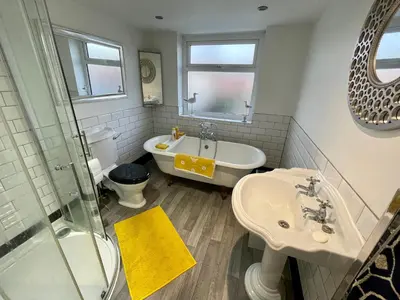 a bathroom with a tub and a sink and a toilet at Honeybee Cottage in Lytham St Annes