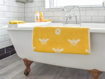 a bath tub with a yellow towel on it at Honeybee Cottage in Lytham St Annes
