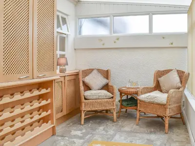 two chairs and a table in a room with a window at Honeybee Cottage in Lytham St Annes
