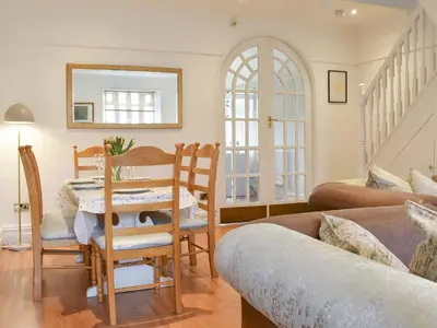a living room with a table and a couch at Honeybee Cottage in Lytham St Annes