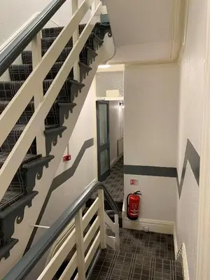 a staircase in a building with a red fire extinguisher at Urban Inn in Blackpool