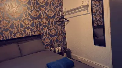 a small bedroom with a bed and a wall with a damascus at Urban Inn in Blackpool