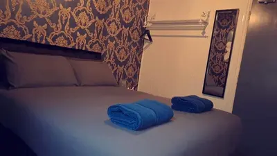 two blue towels sitting on top of a bed at Urban Inn in Blackpool