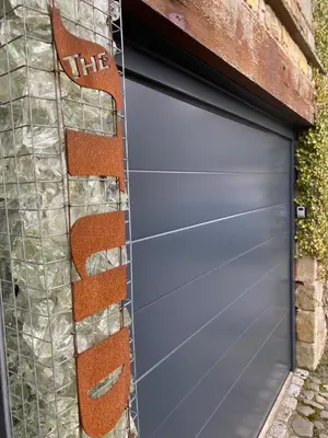 a garage door with the words hire on it at The Artist Studio in Hest Bank