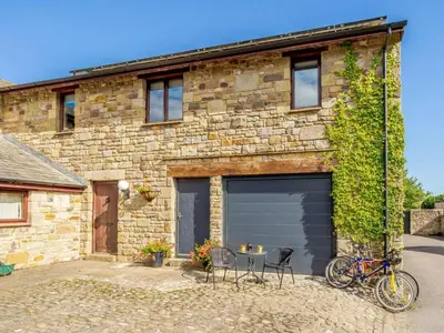 a garage with a bicycle parked in front of a building at The Artist Studio in Hest Bank