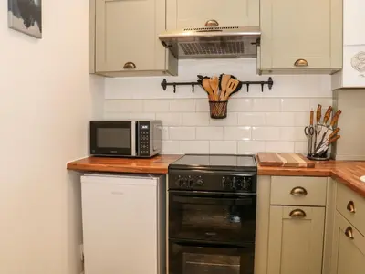 a kitchen with a stove and a microwave at Hope Cottage in Hambleton