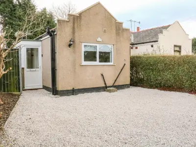 a house with a white door and a fence at Hope Cottage in Hambleton