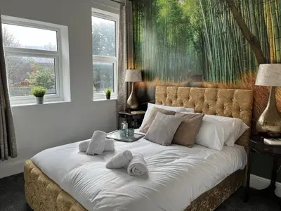 a bedroom with a large bed with towels on it at Modern 1 bed studios for comfy stay in Preston in Preston