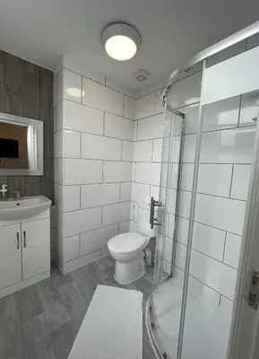 a bathroom with a toilet and a glass shower at Modern 1 bed studios for comfy stay in Preston in Preston