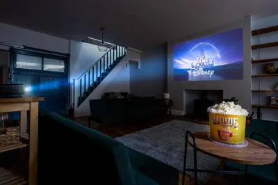 a living room with a couch and a big screen at RST Bramley Moore in Liverpool