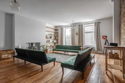 a living room with green couches and a fireplace at RST Bramley Moore in Liverpool