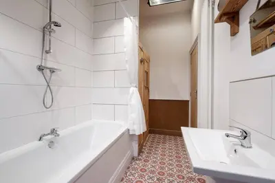 a white bathroom with a tub and a sink at RST Bramley Moore in Liverpool