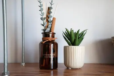 a bottle of essential oil next to a vase with a plant at RST Bramley Moore in Liverpool