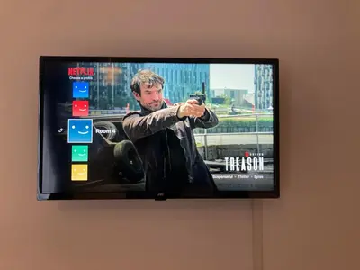 a television hanging on a wall with a man taking a picture at The New Apollo Hotel in Blackpool