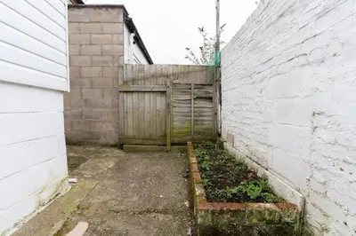 an alley with a wooden gate next to a building at Cheerful and modern 3 BDR for 7 in Liverpool