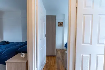a bedroom with a bed and a door leading to a closet at Cheerful and modern 3 BDR for 7 in Liverpool