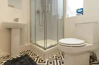 a bathroom with a shower and a toilet and a sink at Cheerful and modern 3 BDR for 7 in Liverpool