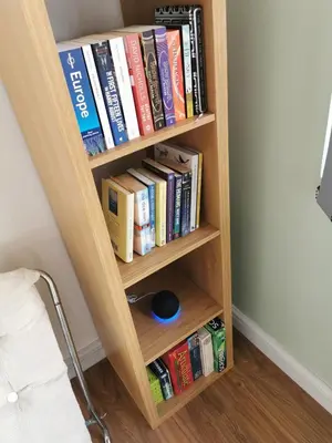 a book shelf filled with books next to a bed at The Bakery in Pilling