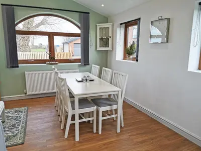 a dining room with a white table and chairs at The Bakery in Pilling