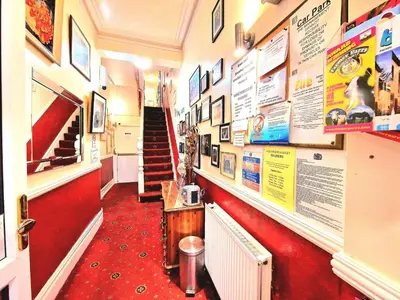 a hallway of a restaurant with a red carpet at Sleep Well Hotel in Blackpool