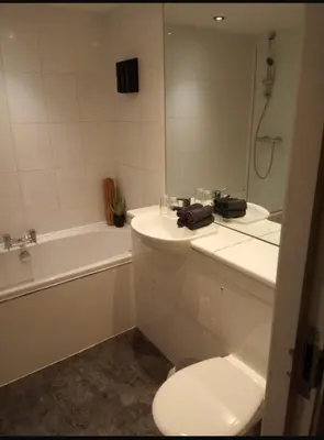 a bathroom with a toilet and a sink and a tub at Stunning Liverpool City Center Apartment in Liverpool