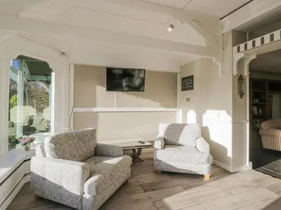 a living room with two chairs and a tv at Valley View in Dalton in Furness