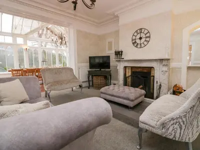 a living room with a fireplace and a clock on the wall at Valley View in Dalton in Furness