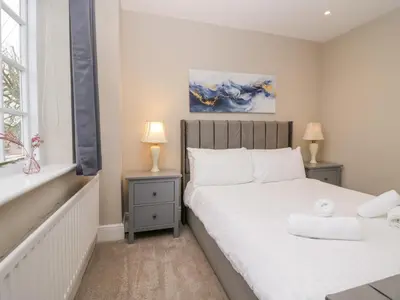 a bedroom with two beds and two lamps and a window at Valley View in Dalton in Furness