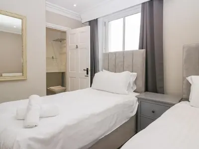 a bedroom with two beds and a mirror at Valley View in Dalton in Furness