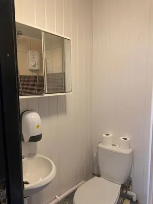 a white bathroom with a toilet and a sink at Black Ocean Holiday Apartments in Blackpool
