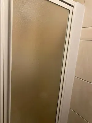 a glass shower door in a bathroom at Black Ocean Holiday Apartments in Blackpool