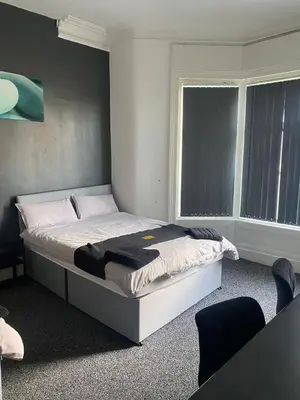 a bed in a room with a large window at Black Ocean Holiday Apartments in Blackpool