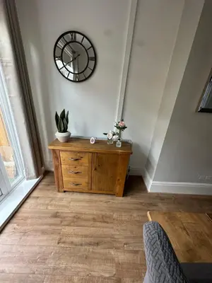 a room with a wooden dresser and a clock on the wall at Watford Road House Liverpool in Liverpool