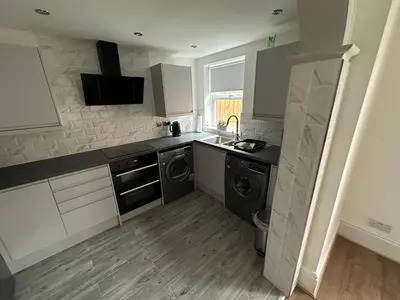 a kitchen with a sink and a washing machine at Watford Road House Liverpool in Liverpool