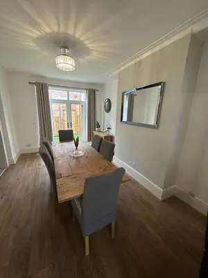 a dining room with a wooden table and chairs at Watford Road House Liverpool in Liverpool