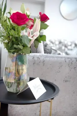 a vase filled with roses sitting on a table at Garden by the Bay Southport in Southport