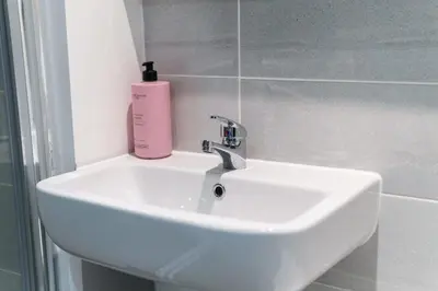a bathroom sink with a pink soap bottle on it at Lovely 1 Bed Apartment in Central Liverpool in Liverpool