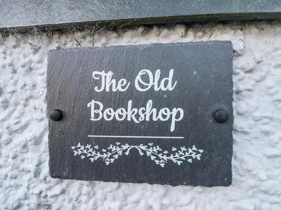 a sign on a wall that says the old bookstore at Old Book Shop in Grange Over Sands