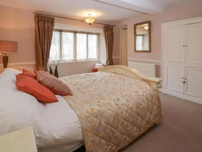 a bedroom with a large bed with red pillows at Old Book Shop in Grange Over Sands