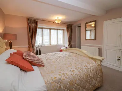 a bedroom with a large bed with red pillows at Old Book Shop in Grange Over Sands