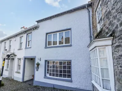 a white house with windows and a door at Old Book Shop in Grange Over Sands