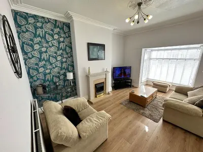 a living room with a couch and a fireplace at Spacious one bedroom apartment in central location in Lytham St Annes