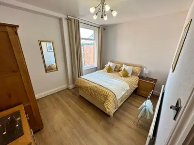 a small bedroom with a bed and a window at Spacious one bedroom apartment in central location in Lytham St Annes