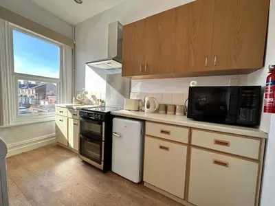 a kitchen with a microwave and a stove top oven at Spacious one bedroom apartment in central location in Lytham St Annes
