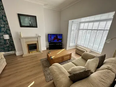a living room with a couch and a fireplace at Spacious one bedroom apartment in central location in Lytham St Annes