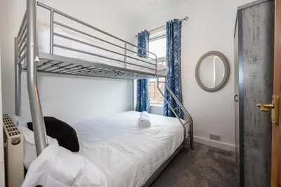 a bedroom with two bunk beds and a mirror at Cosy Two bedroom Terrace Blackburn in Cherry Tree
