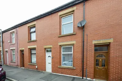 a red brick building with windows and a door at Cosy Two bedroom Terrace Blackburn in Cherry Tree