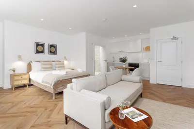 a white living room with a bed and a couch at 40 Renshaw Apartments in Liverpool