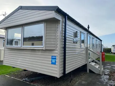 a small silver trailer with a door and a window at The SandyBel Caravan in Cark