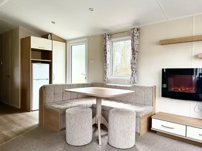 a living room with a table and a couch at The SandyBel Caravan in Cark